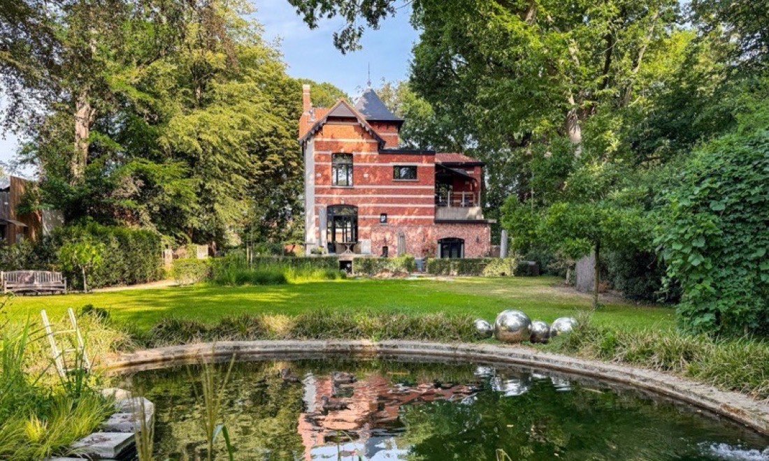 De zwemvijver met daarachter het huis, in zomerlicht