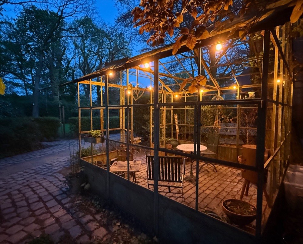 De serre in de tuin bij avondlicht